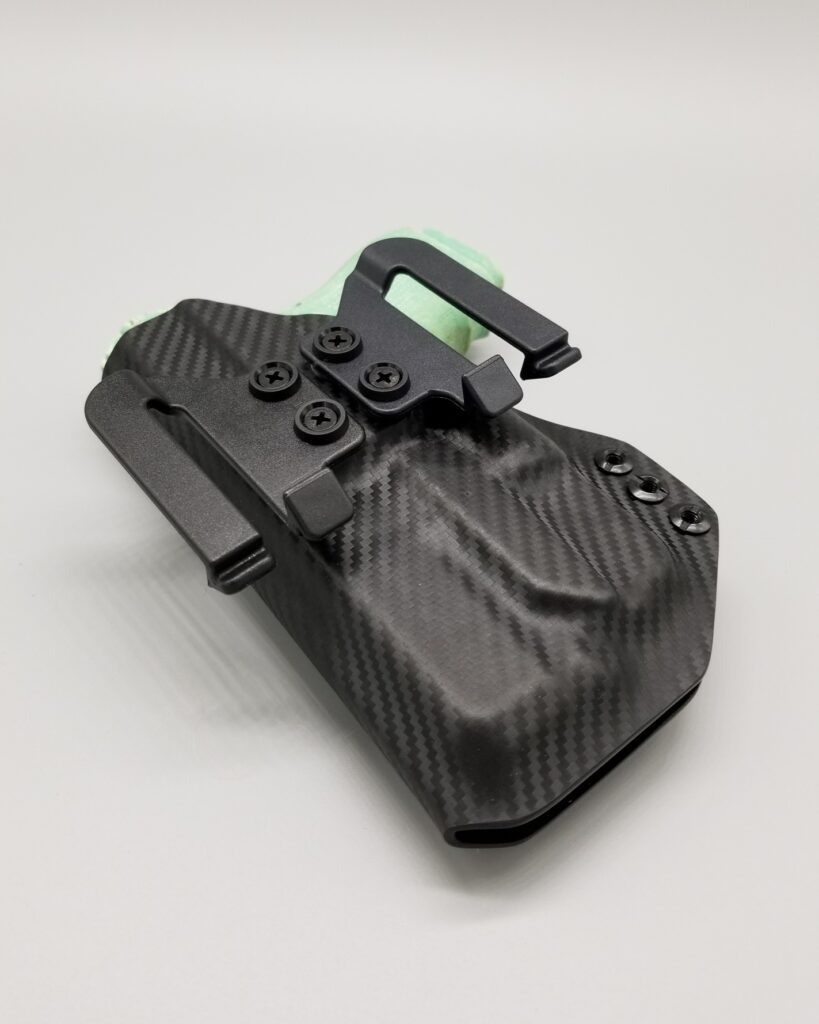 Black carbon fiber Hermes Series light-bearing Kydex holster with a green accent