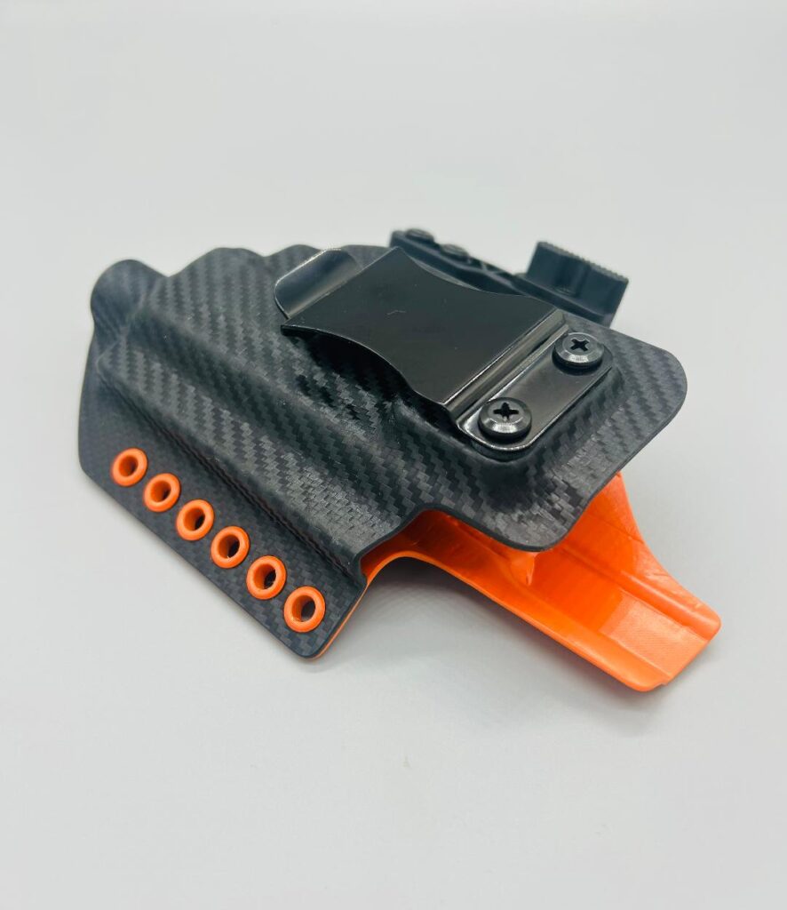 Black carbon fiber Theseus 2.0 Kydex IWB holster with orange hardware and a claw