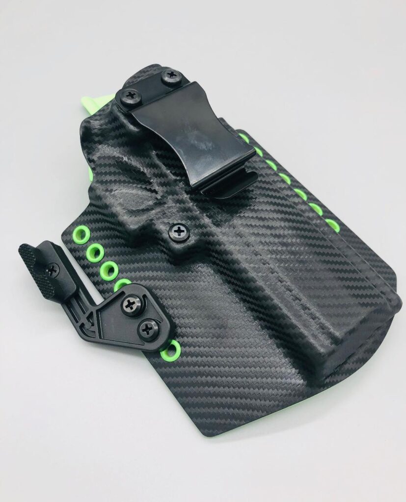 Black carbon fiber Theseus 2.0 Kydex IWB holster with green hardware and a belt clip